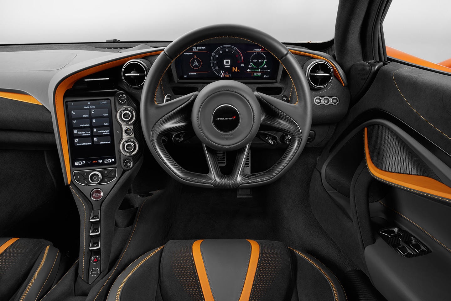 Vista al volante y controles centrales del McLaren 720S, acabados en negro y naranja.