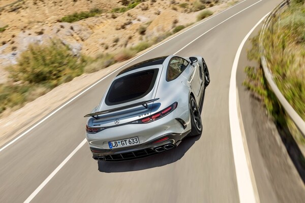 Trasera del Mercedes-AMG GT en movimiento, exhibiendo sus líneas y luces LED. Trasera del Mercedes-AMG GT en movimiento, exhibiendo sus líneas y luces LED.