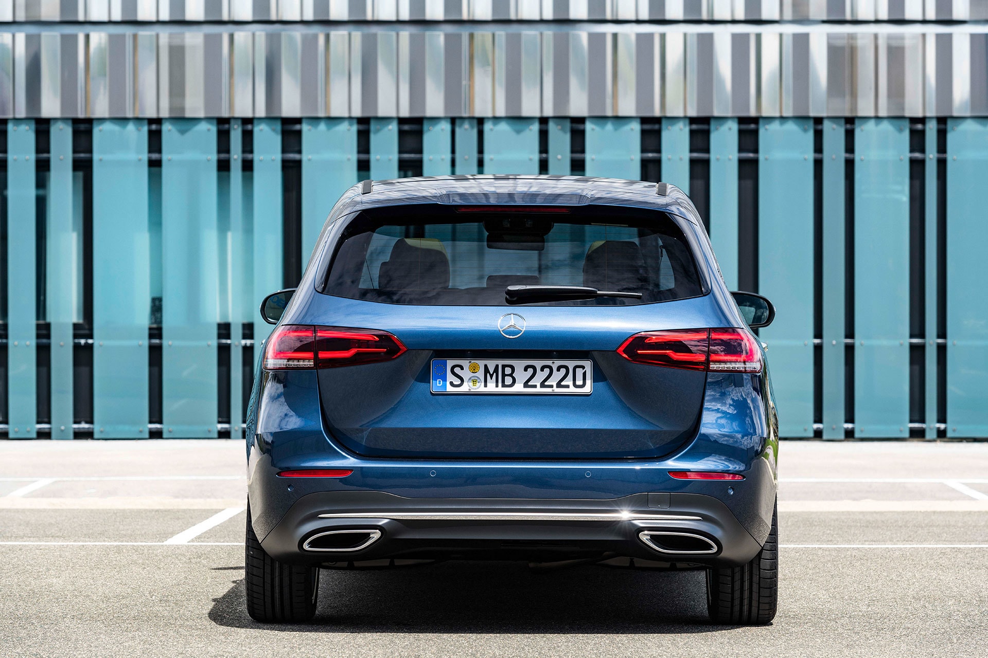 Vista trasera del vehículo con una estructura moderna de fondo.