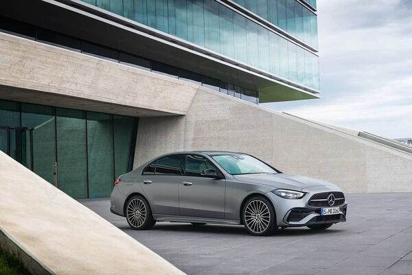 Elegancia y modernidad: Mercedes Clase C Híbrido delante de arquitectura contemporánea