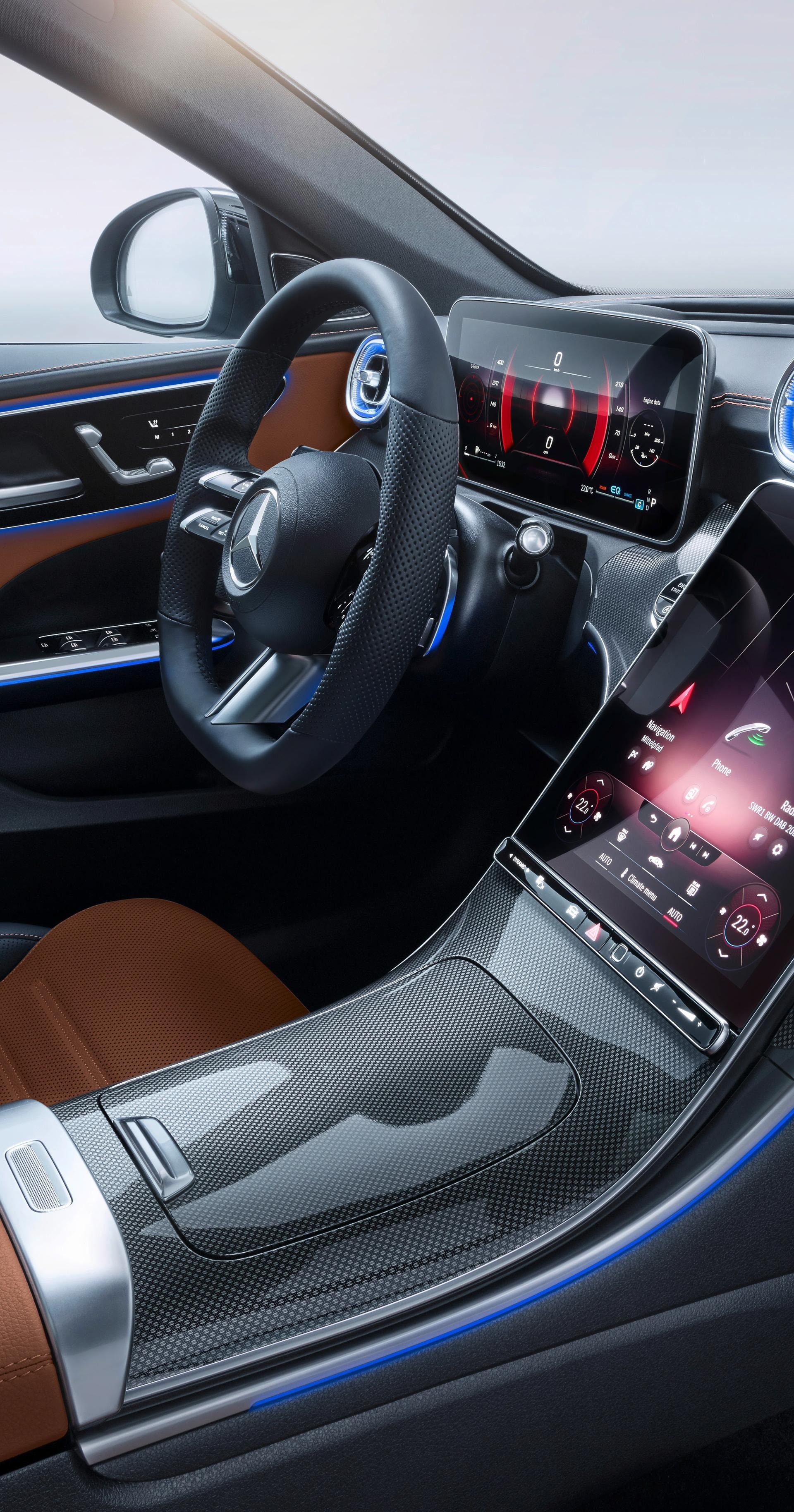 Vista del volante deportivo y asientos en tonos marrón y negro.