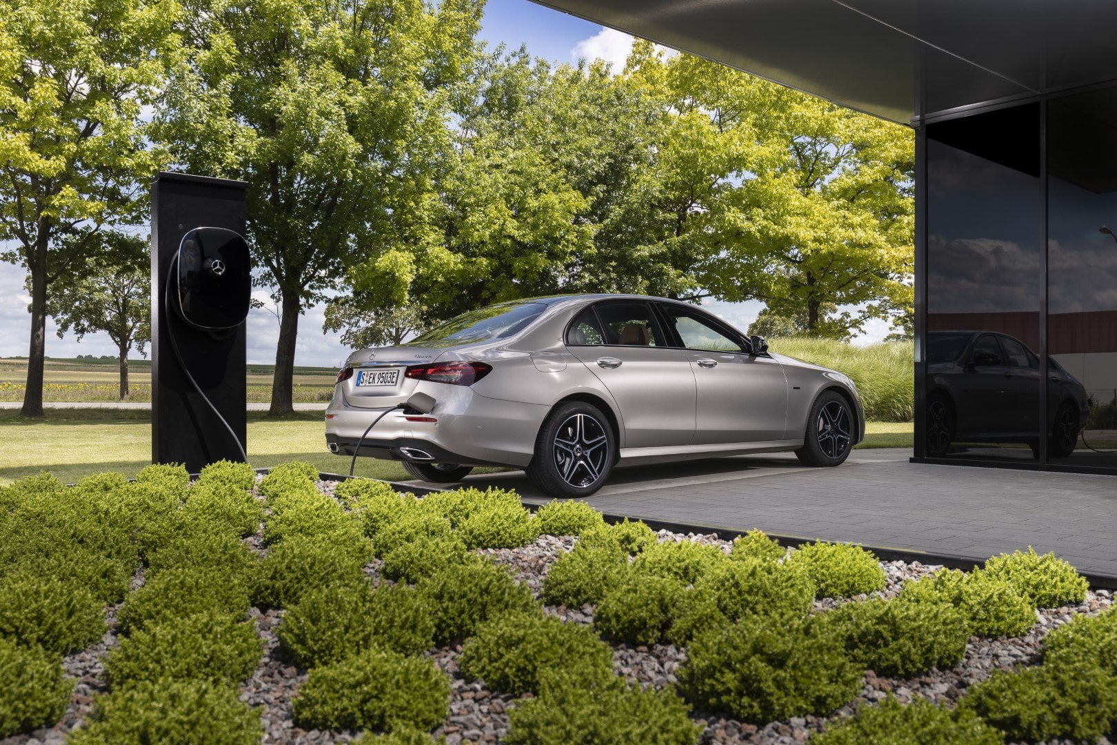 Vista trasera del Mercedes Clase E en una estación de carga para vehículos híbridos.