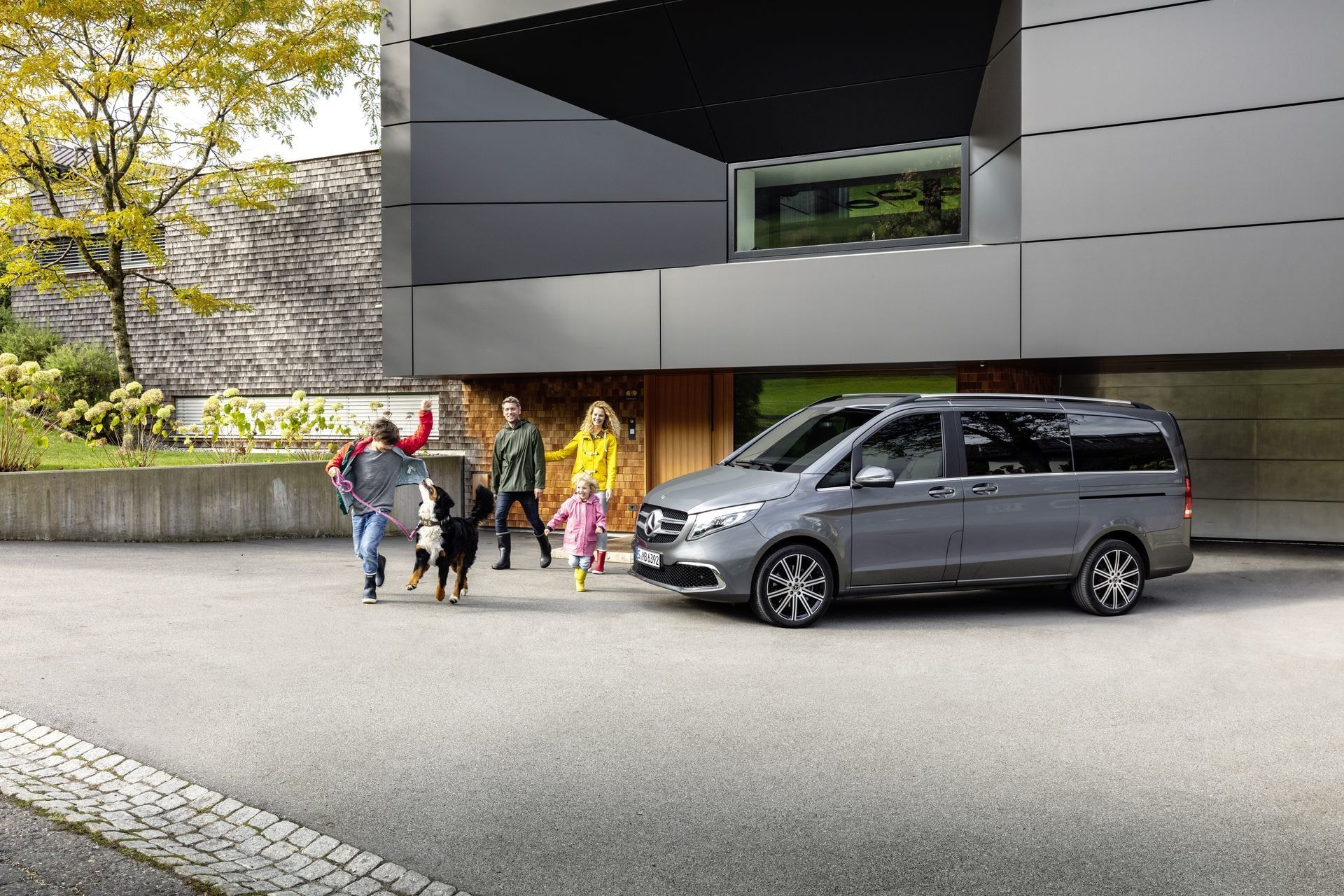 Vista lateral de un Mercedes Clase V con una familia al lado