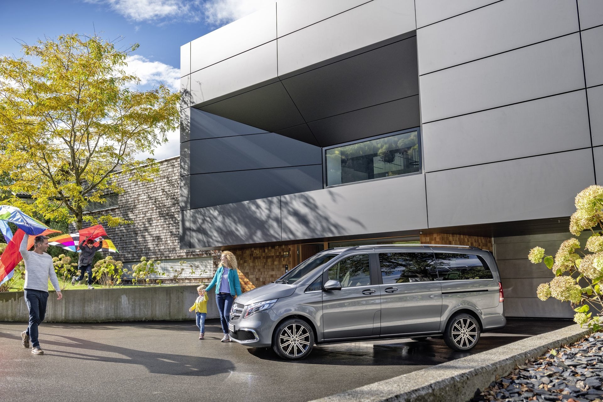 Familia disfrutando de un momento junto al Mercedes Clase V lateral