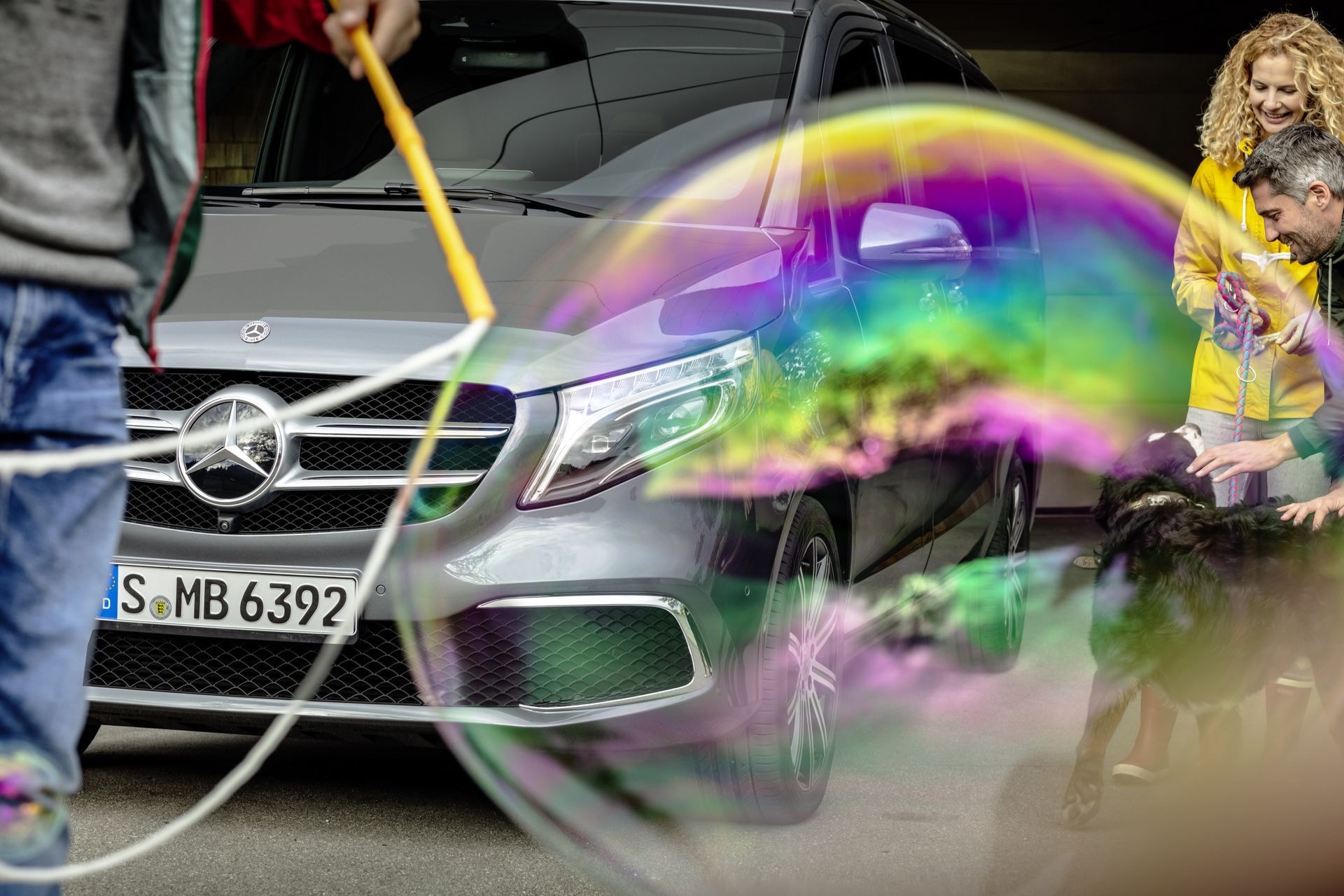 Composición dinámica con Clase V y juego de burbujas, subraya su enfoque en la familia.