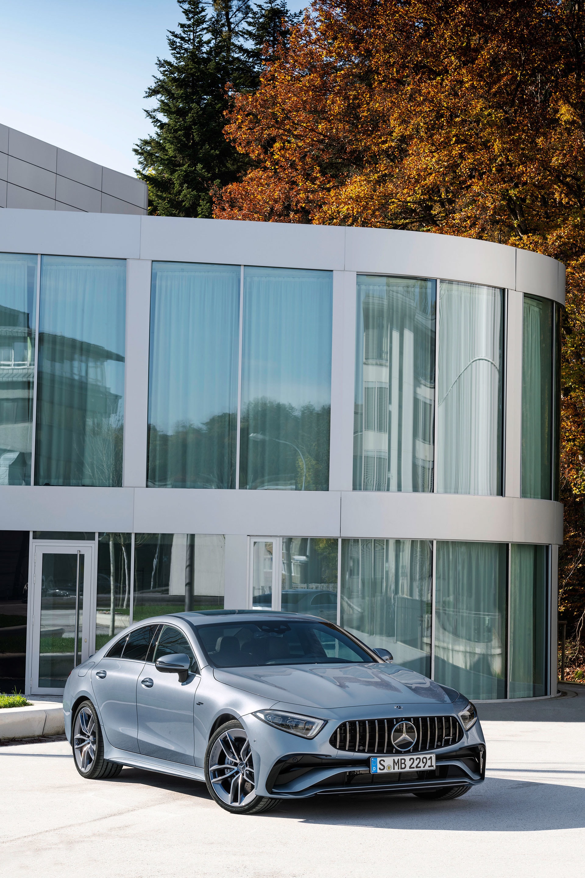 Frente del Mercedes CLS captado frente a un moderno edificio de cristal.