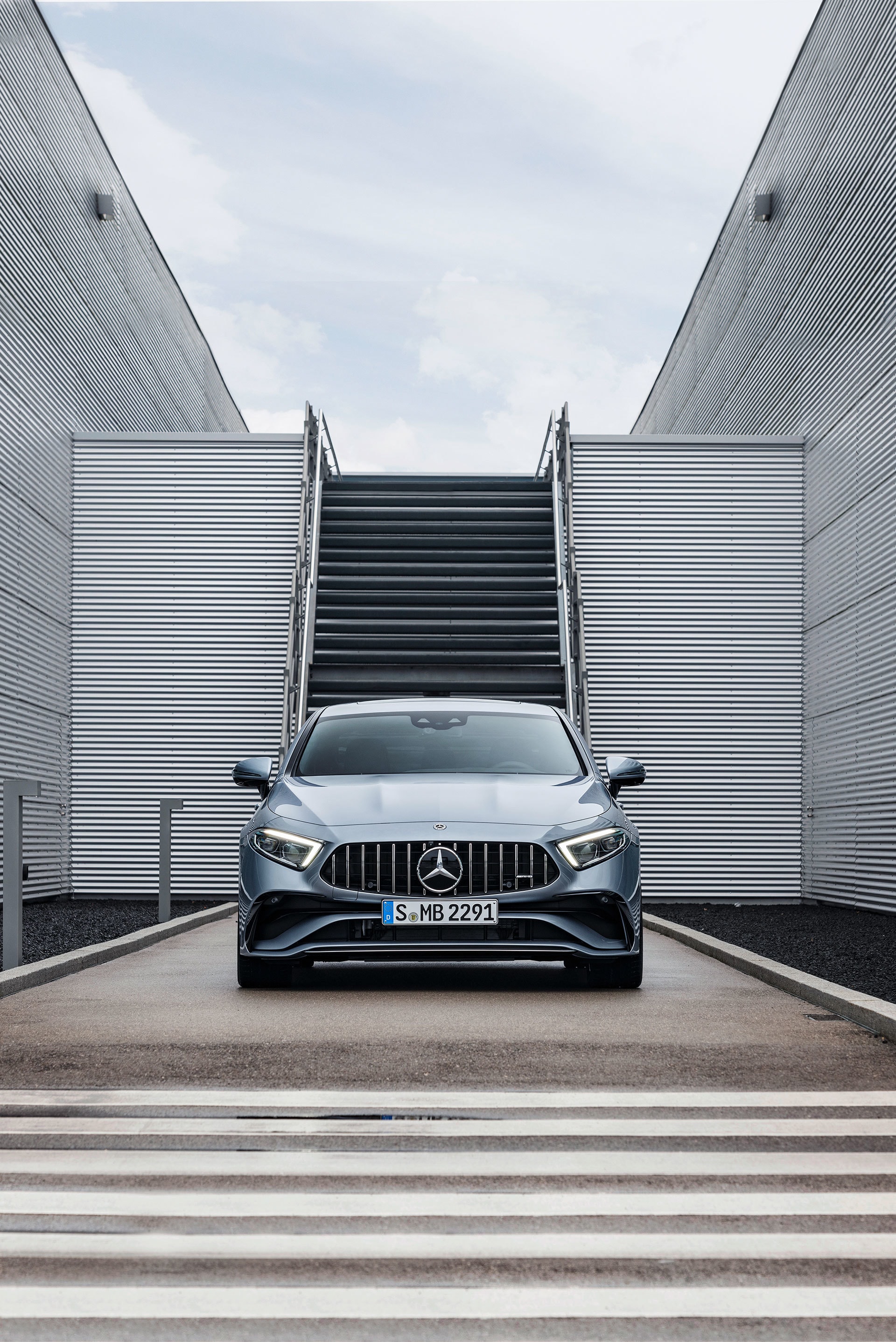 Frente del Mercedes CLS en armonía con una arquitectura moderna y escaleras.