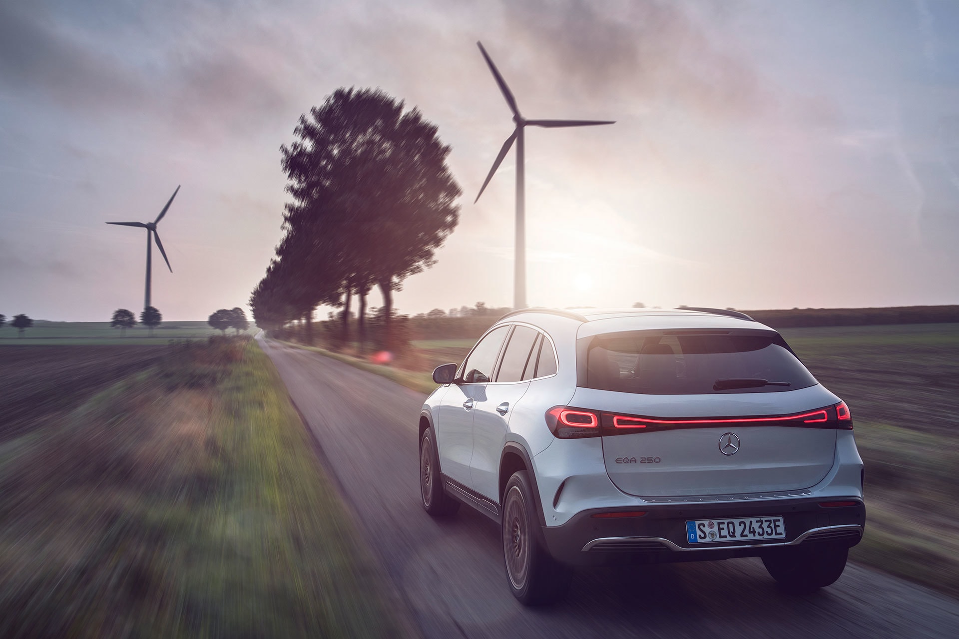 Vista trasera y lateral del EQA con un atardecer, destacando su diseño y tecnología sostenible.