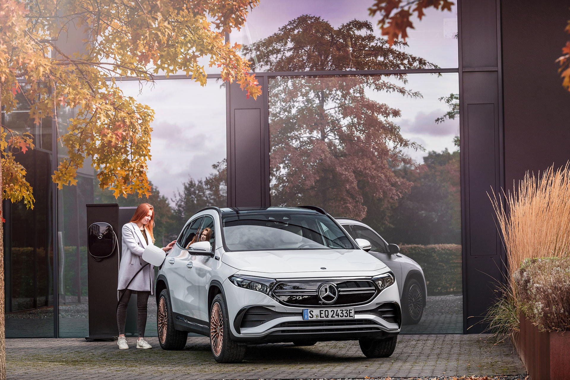 Usuario cargando su Mercedes EQA en un entorno otoñal