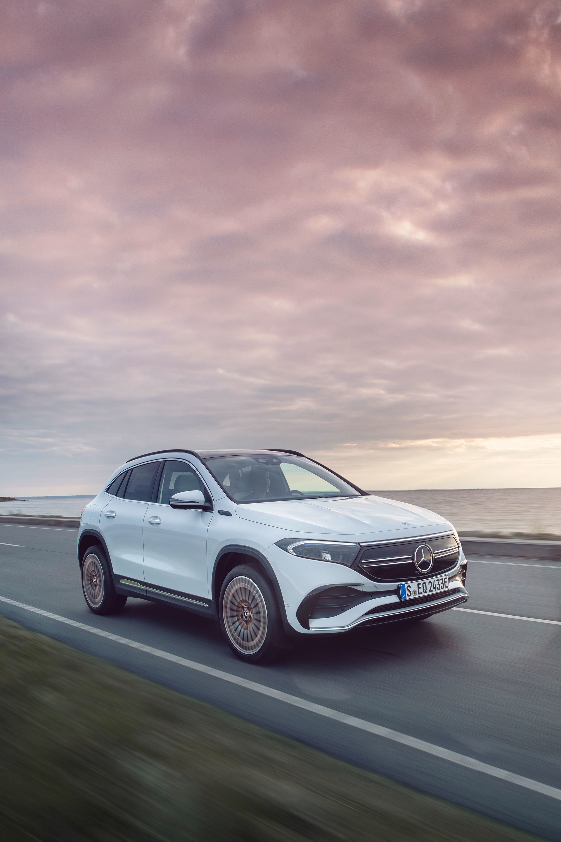 Vista lateral del Mercedes EQA en movimiento mostrando dinamismo y diseño fluido.