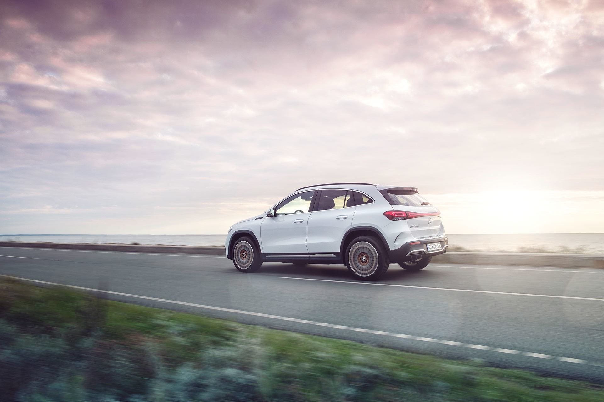 Mercedes EQA en perspectiva lateral mientras circula por la carretera, subrayando su silueta distintiva.