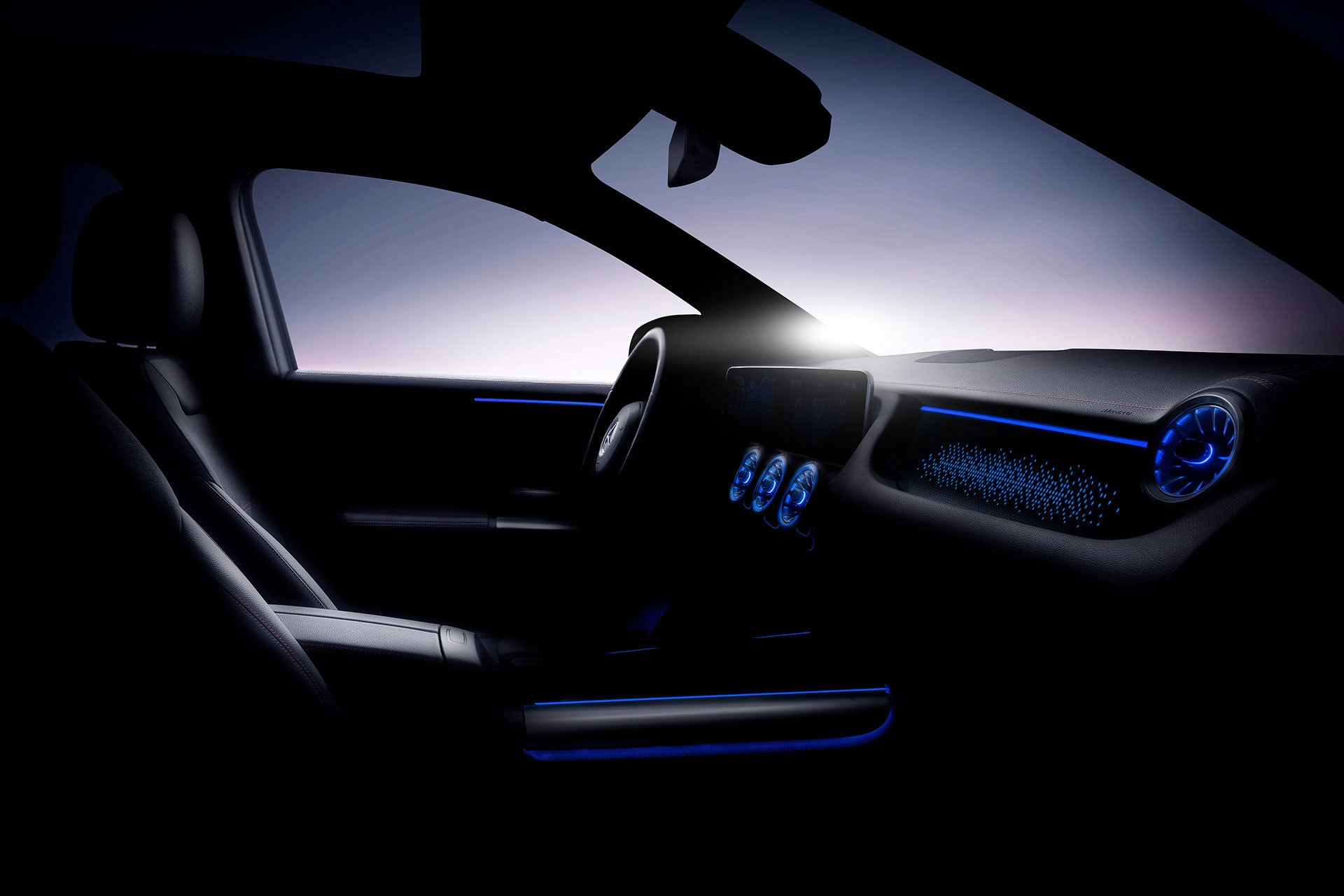 Imagen oscura que resalta la iluminación del panel digital y volante del EQA.