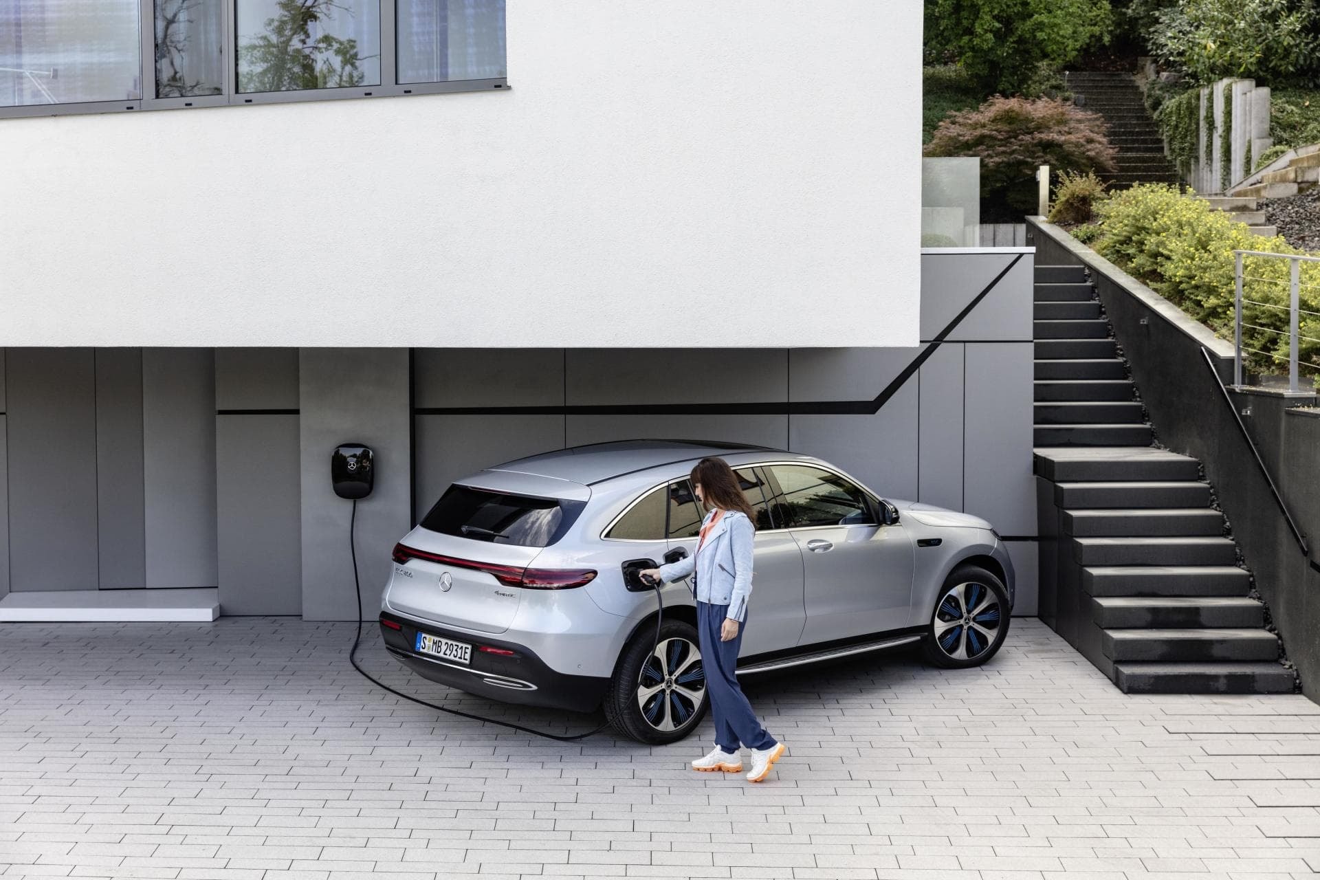 Mercedes EQC cargándose en una residencia, resaltando su funcionalidad.