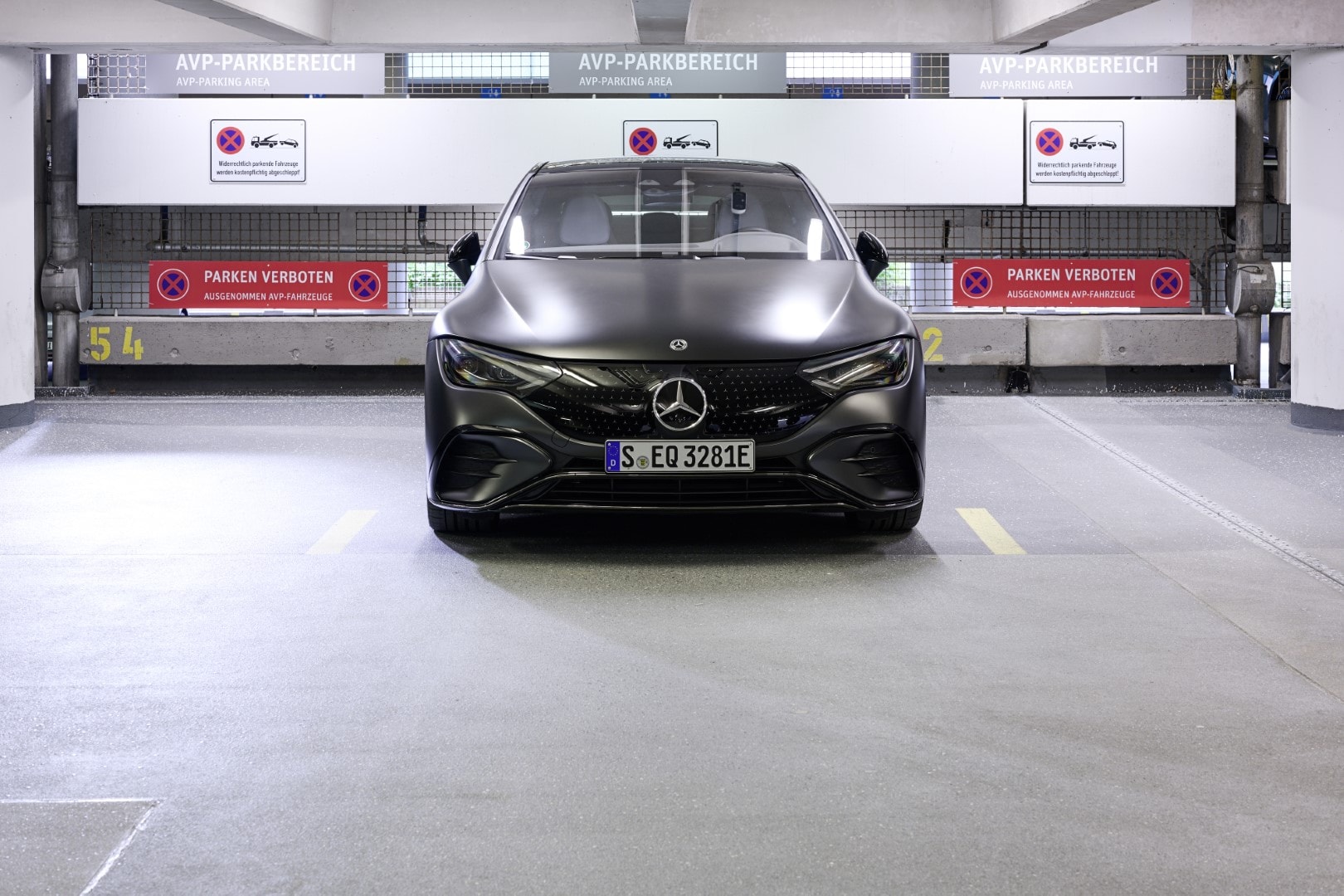 Vista frontal del Mercedes EQE en parking, líneas aerodinámicas destacadas.