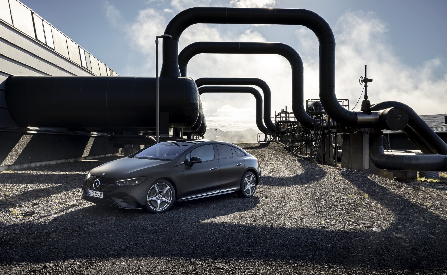 Vista lateral del Mercedes EQE con fondo industrial.