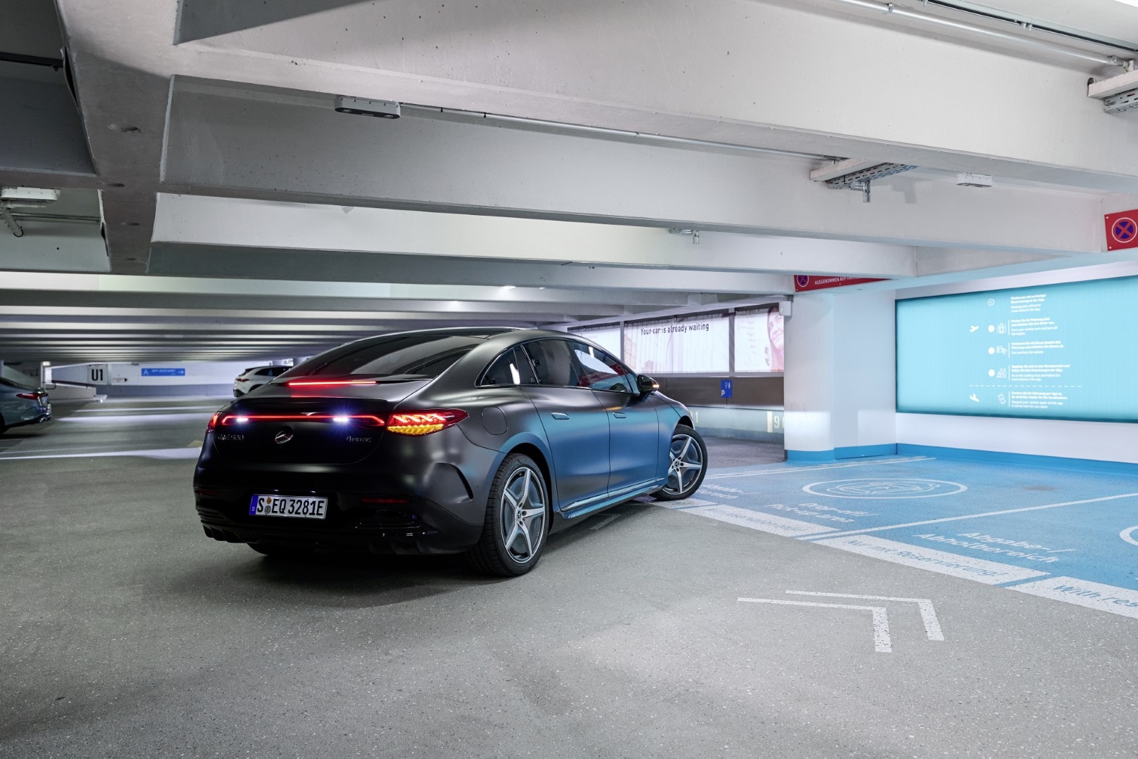 Vista trasera Mercedes EQE en parking, diseño y luces característicos.