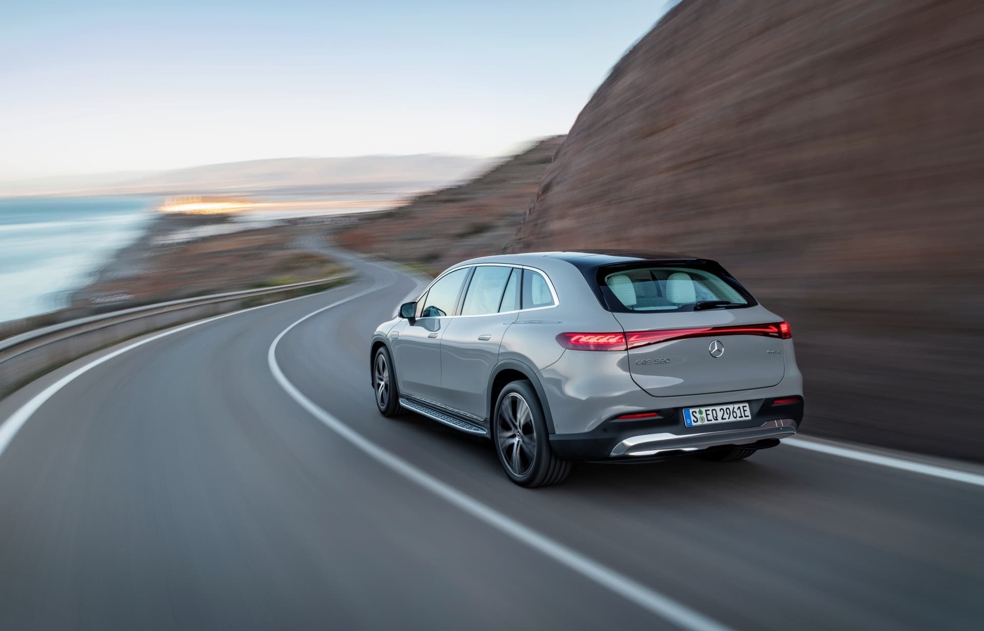 Perspectiva trasera y lateral del EQS SUV ilustrando su poderosa estampa en carretera.