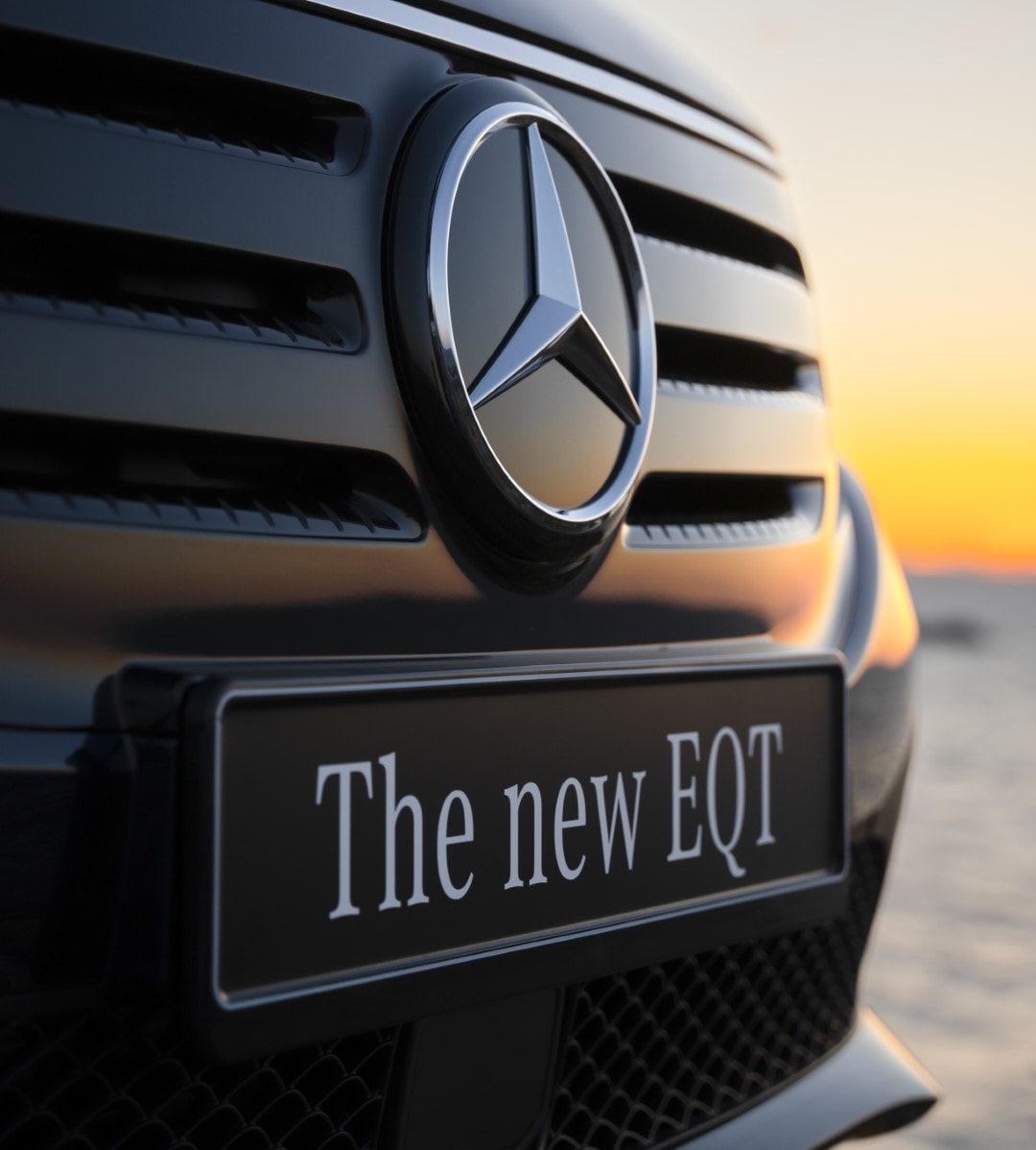 Detalle frontal del EQT con una puesta de sol de fondo, destacando la elegancia de su parrilla.