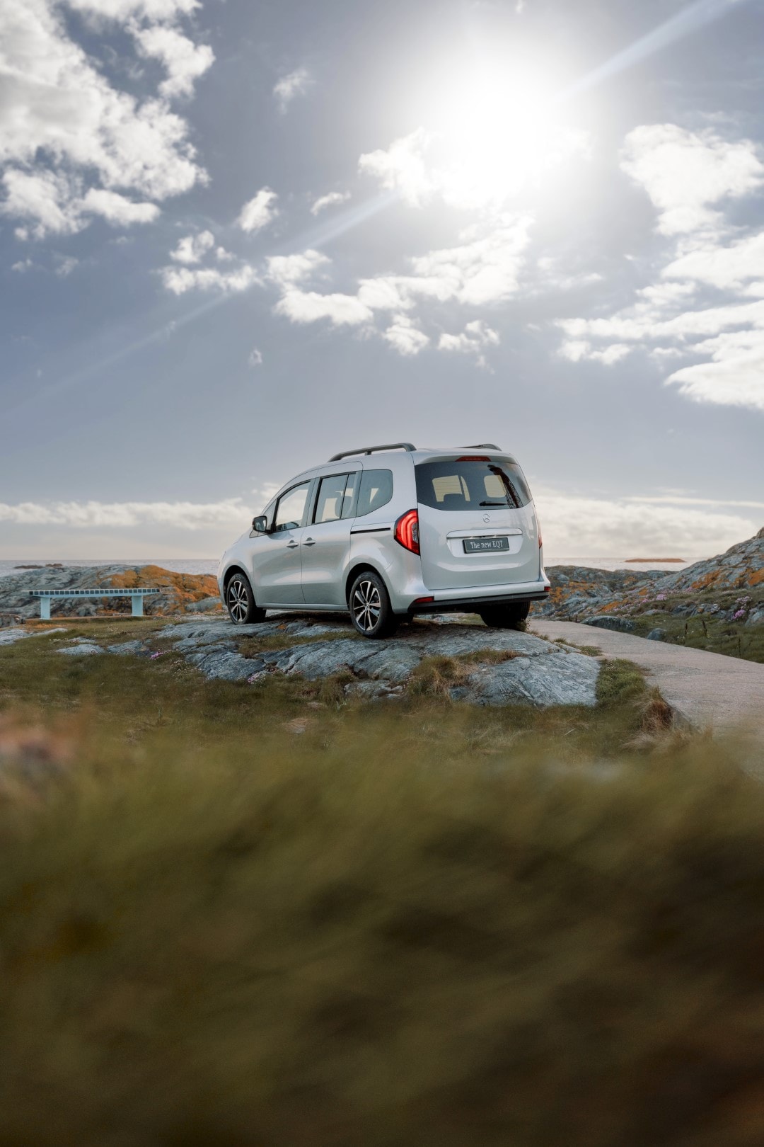Contraluz del Mercedes EQT con una vista trasera lateral en un entorno natural durante el atardecer.
