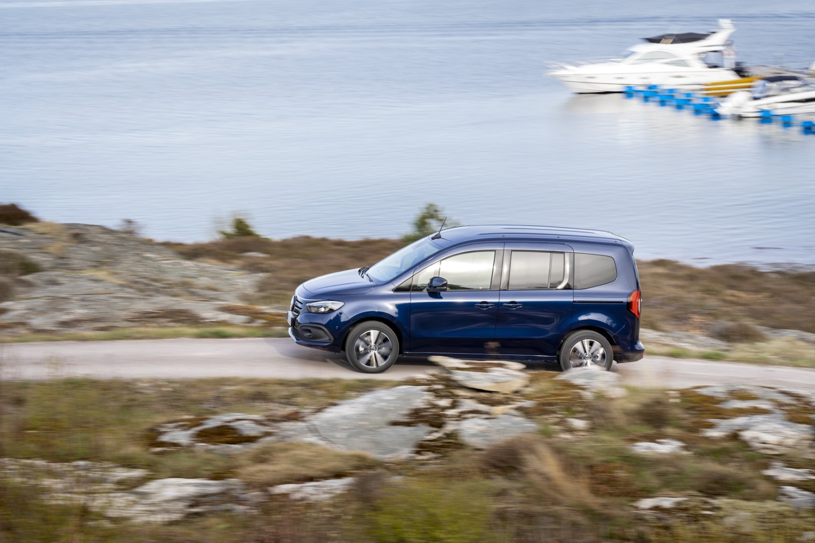 Perfil lateral del Mercedes EQT en un camino costero, demostrando su diseño y capacidad para viajar.
