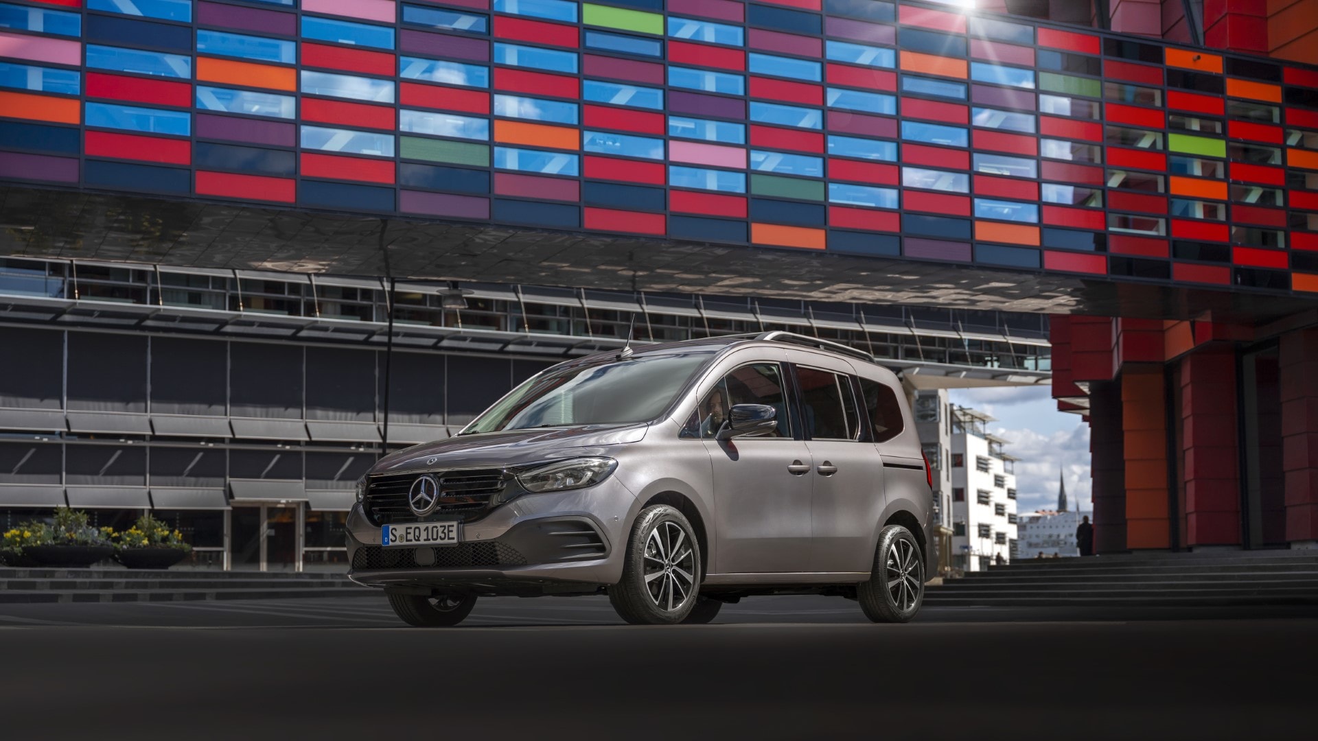 Vista lateral del Mercedes EQT con iluminación urbana de fondo, destacando su diseño.