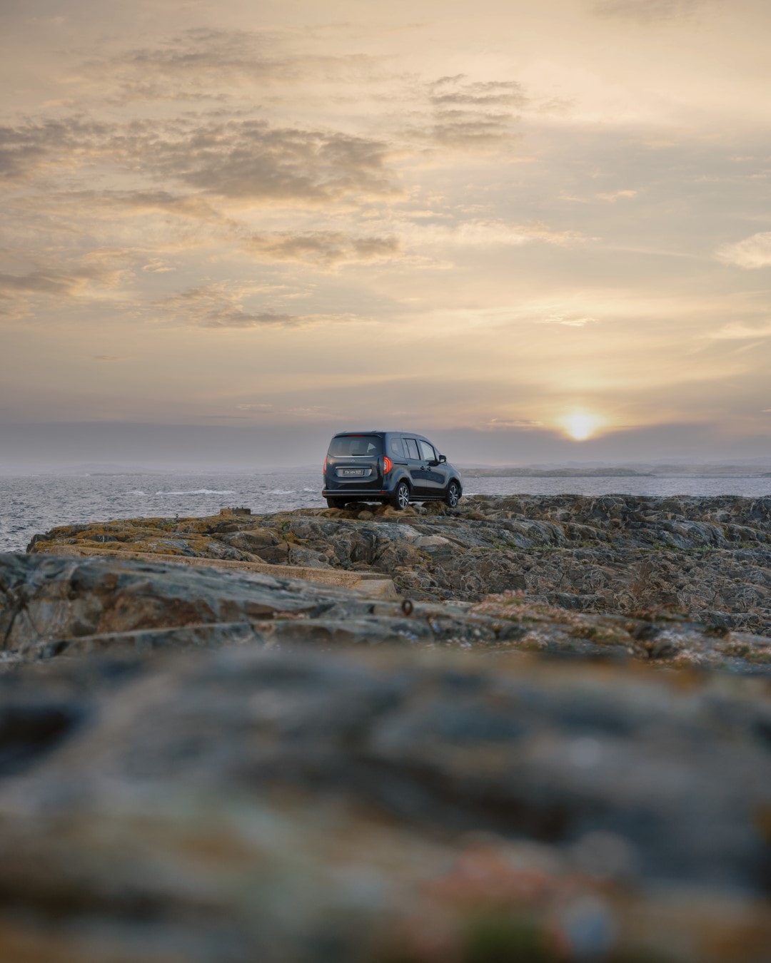 El Mercedes EQT capturado en un paisaje rocoso al atardecer, majestuosa vista.