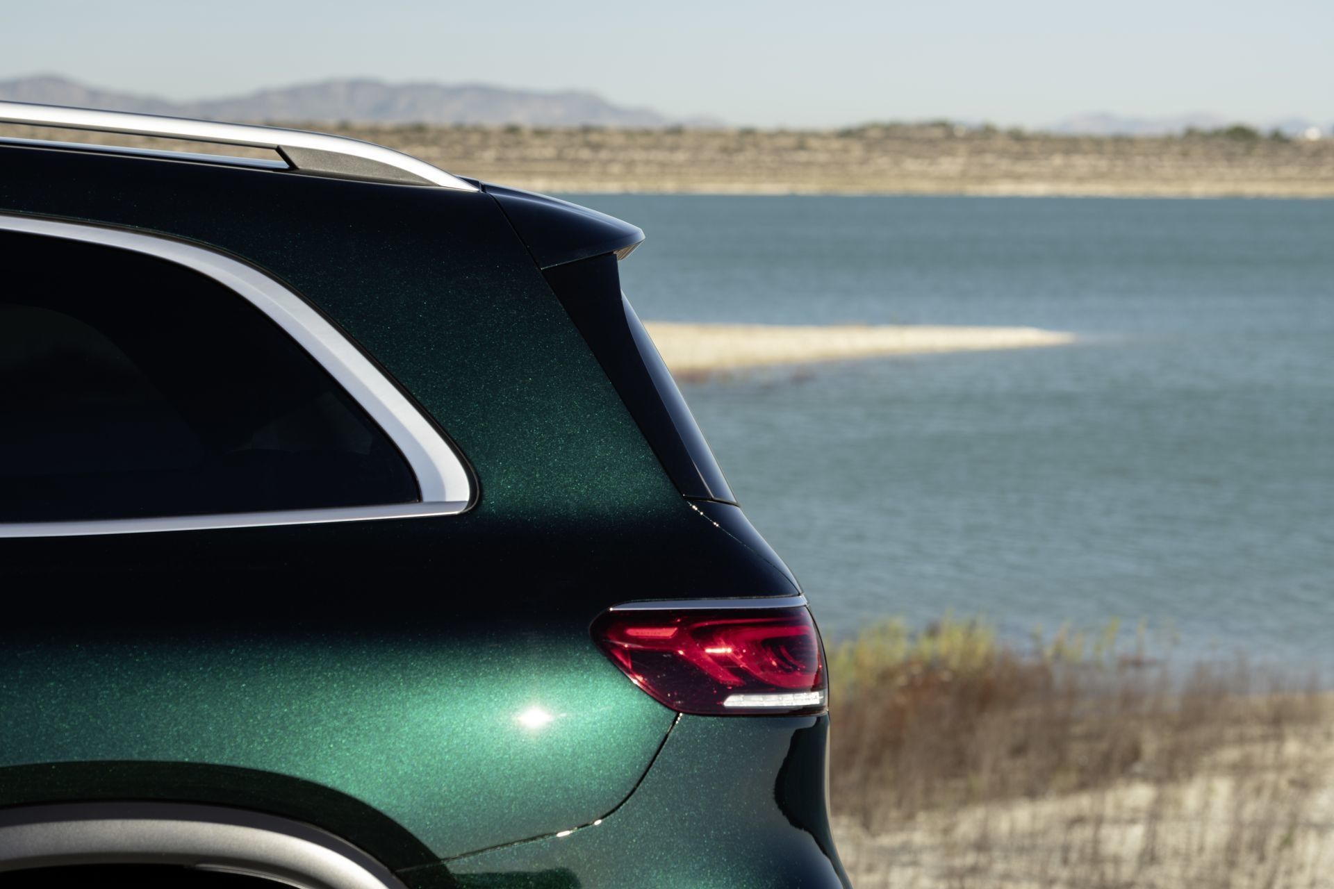 Elegante vista trasera lateral del GLS junto a un paisaje de lago.