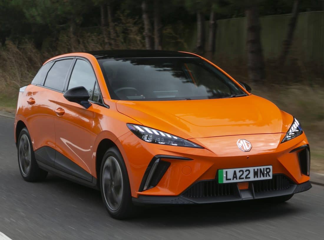 Un MG 4 naranja capturado en movimiento, resaltando su frontal deportivo.