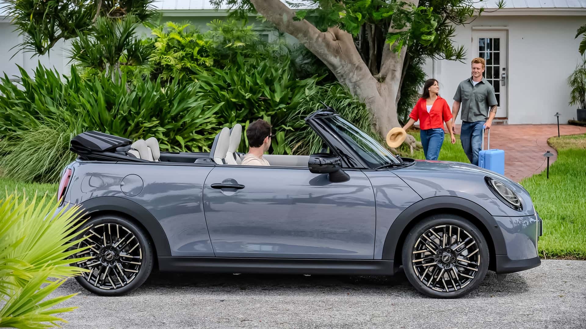 MINI Cabrio parado, con el techo plegado, integrándose perfectamente en el ambiente familiar.