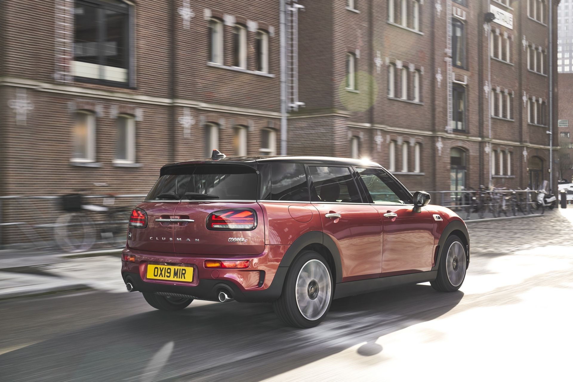 El MINI Clubman en una escena urbana, mostrando su trasera y detalles como las luces y la matrícula.