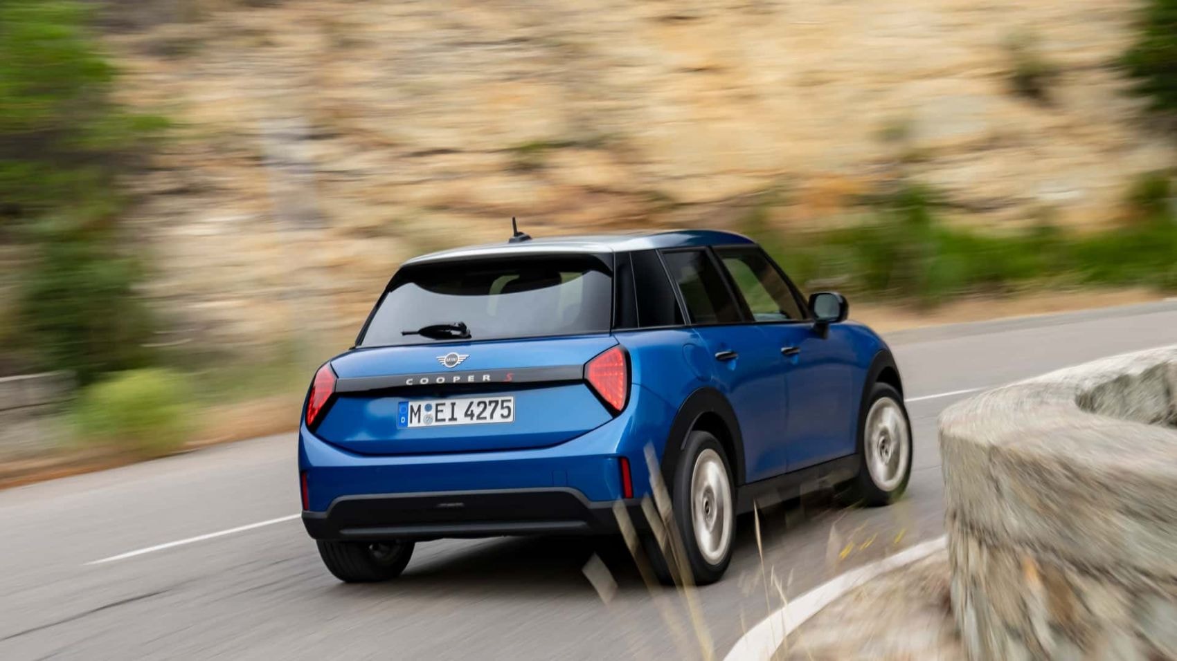 Vista posterior del Mini 5 Puertas con un fondo arquitectónico, enfatizando su atractivo.