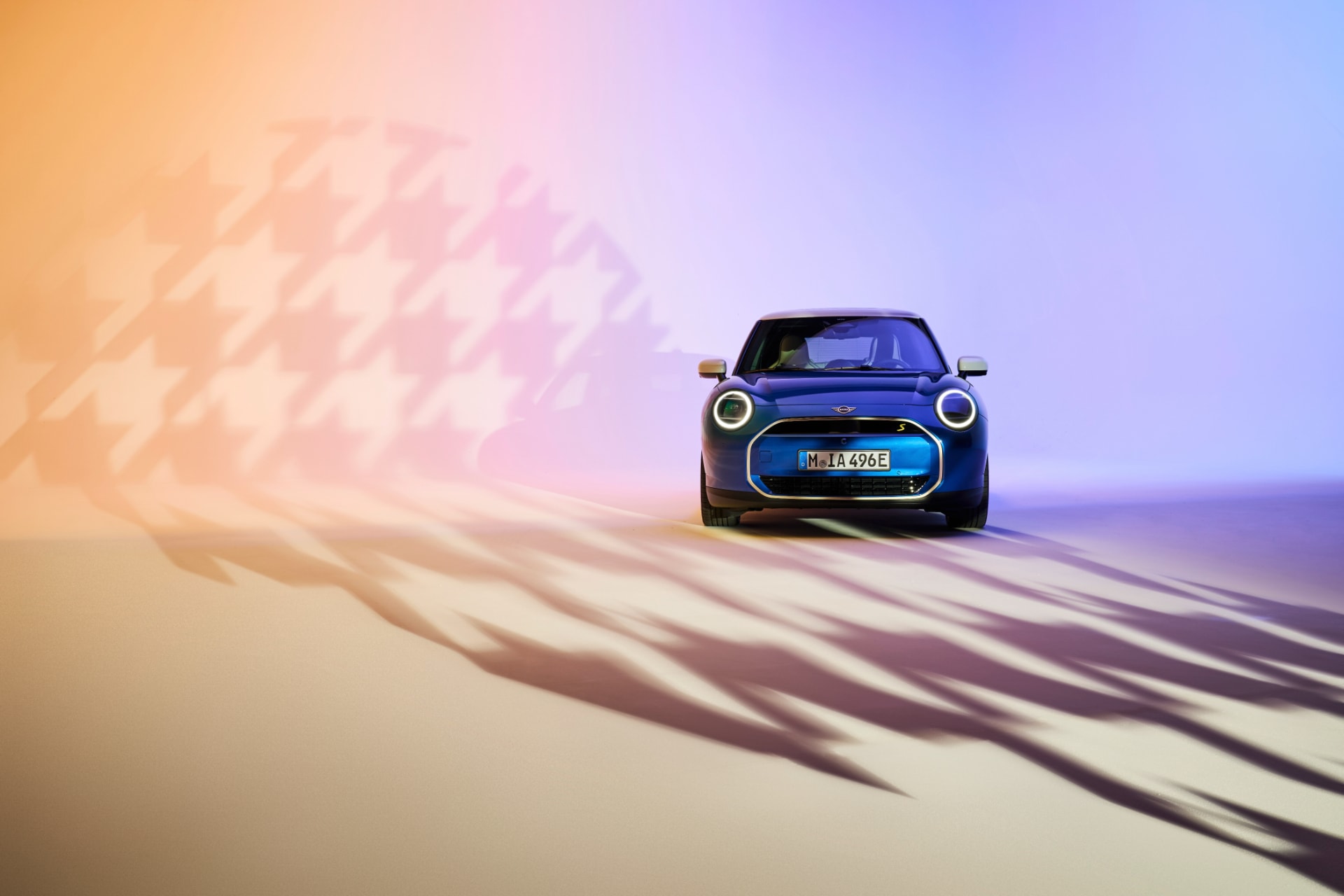 El MINI Cooper SE bajo iluminación que resalta su contorno y diseño frontal.