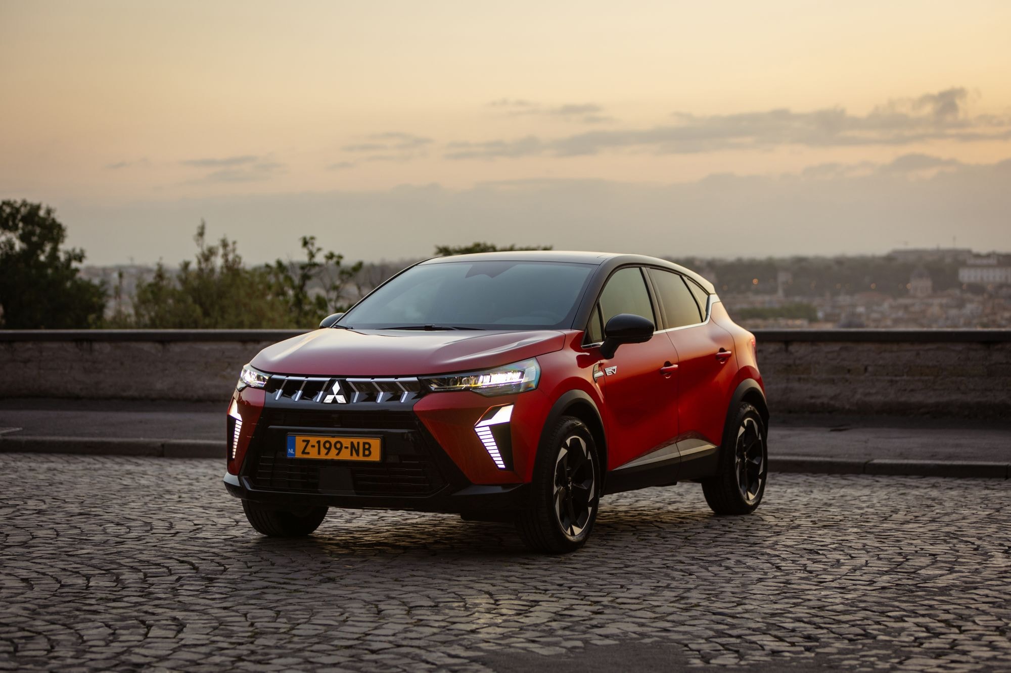 Primer plano del Mitsubishi ASX híbrido con un fondo de atardecer impresionante.