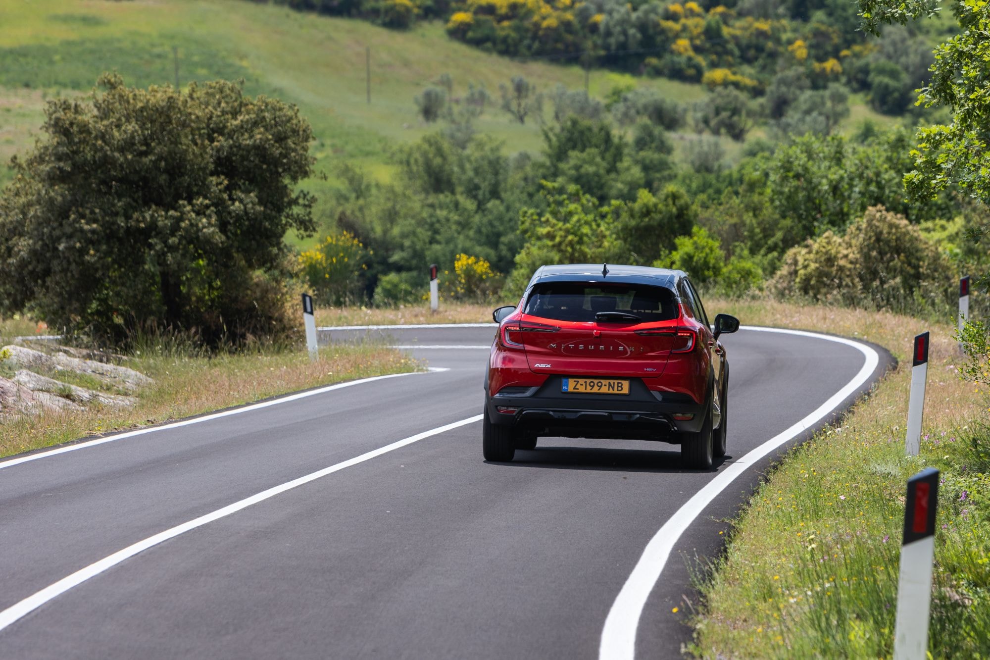 ASX híbrido estacionado ante una impresionante fachada, evidencia de su elegancia.