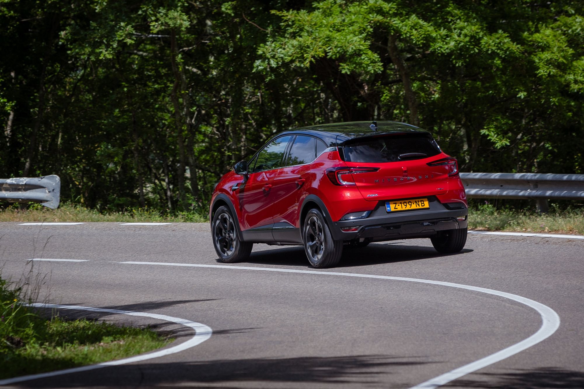 Vista trasera dinámica del ASX híbrido en un paisaje natural.