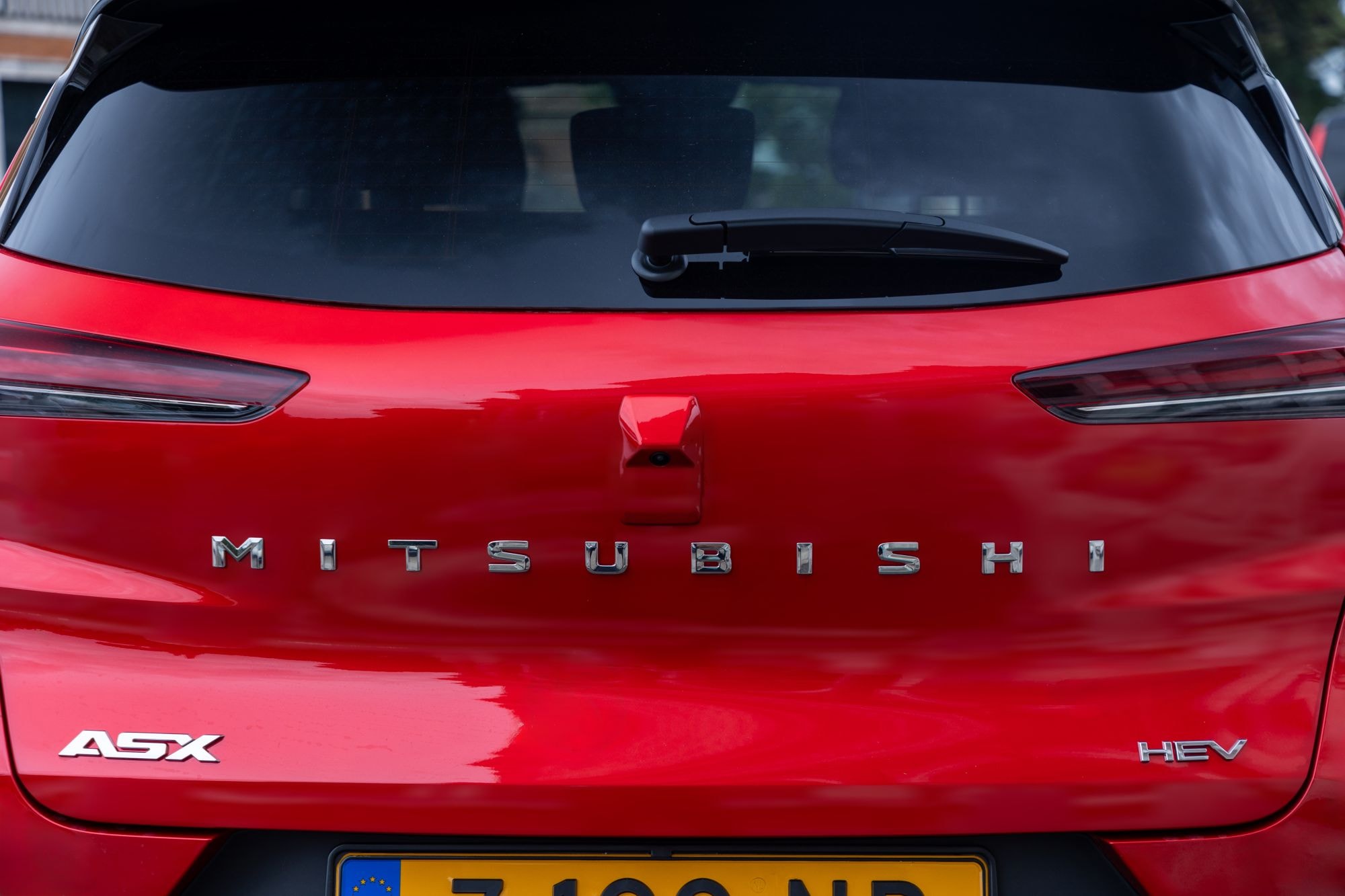 Vista lateral del Mitsubishi ASX híbrido mostrando el logo híbrido.