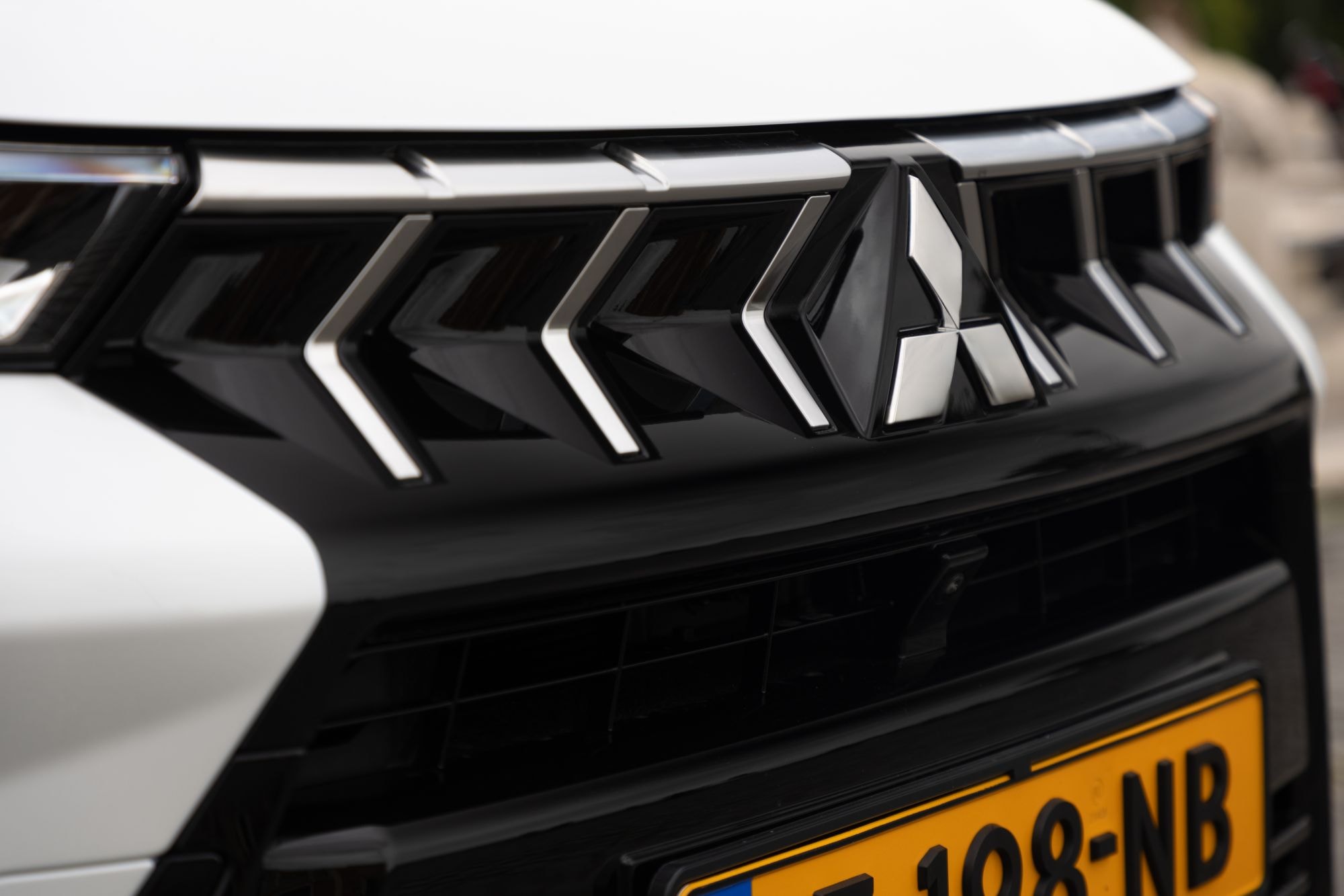 Vista lateral del faro delantero, resaltando su diseño angular y tecnología LED.