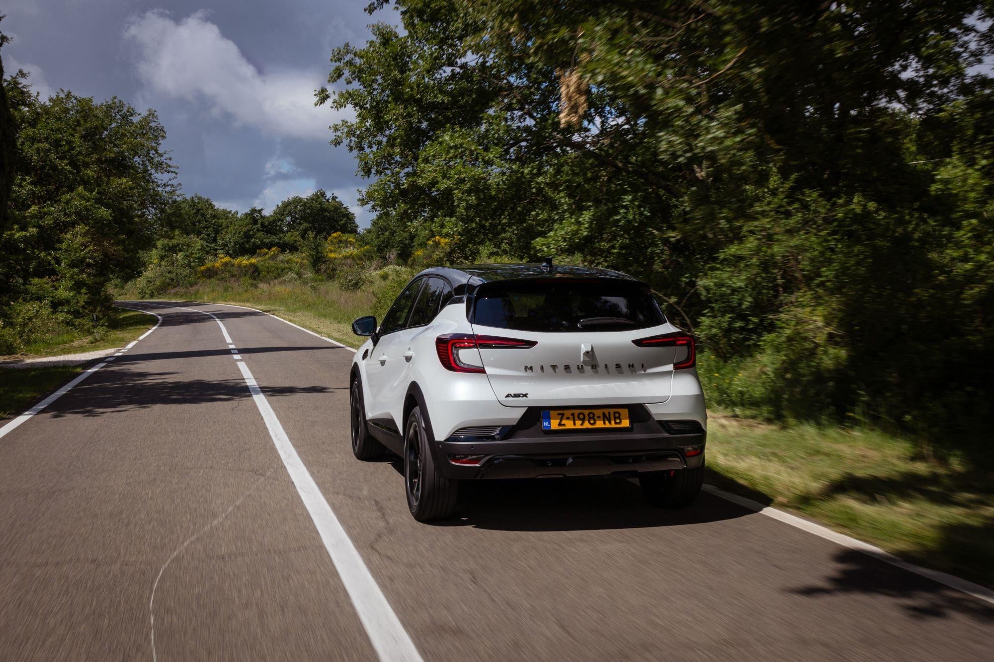 Perfil trasero del ASX en conducción, resaltando su elegante diseño