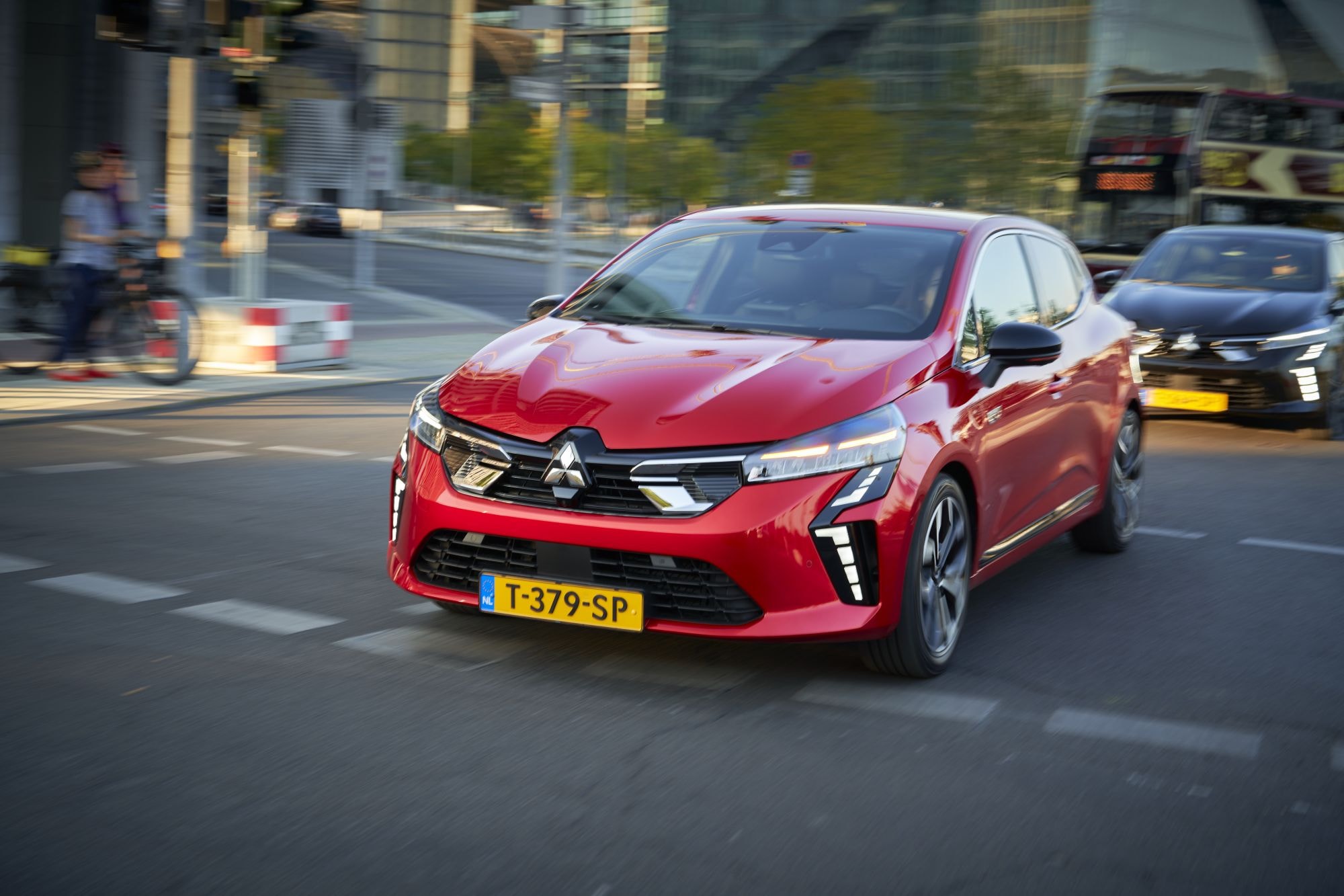 Mitsubishi Colt híbrido conduciendo al atardecer.