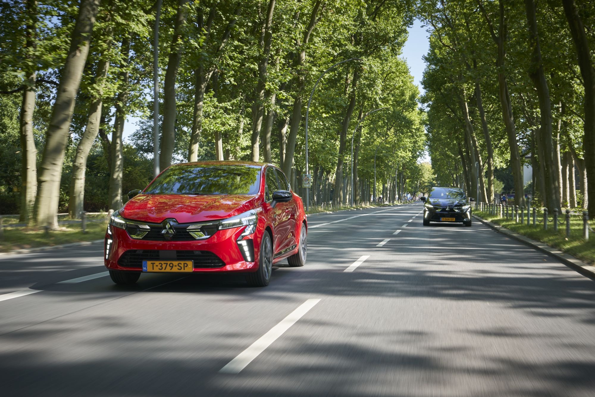 Mitsubishi Colt híbrido en movimiento sobre un puente moderno.