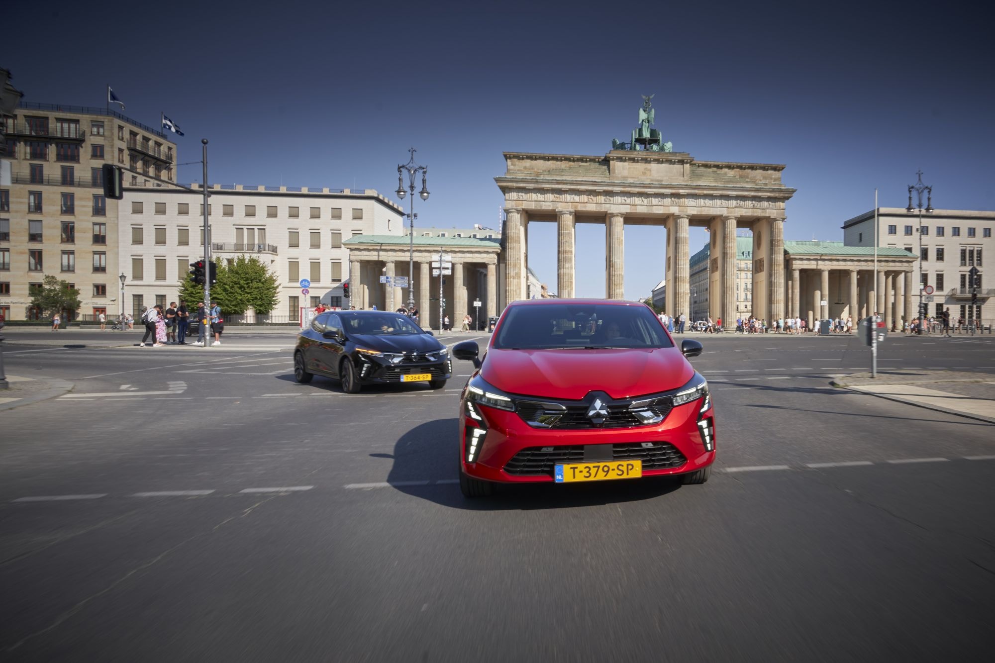 Mitsubishi Colt híbrido transitando por un camino arbolado.