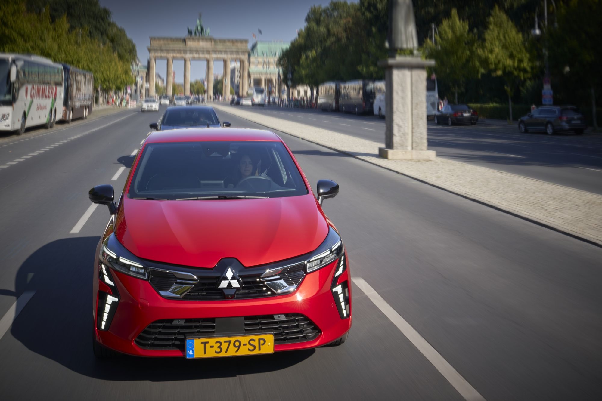 Mitsubishi Colt híbrido en pleno centro turístico, destacándose en la calle.