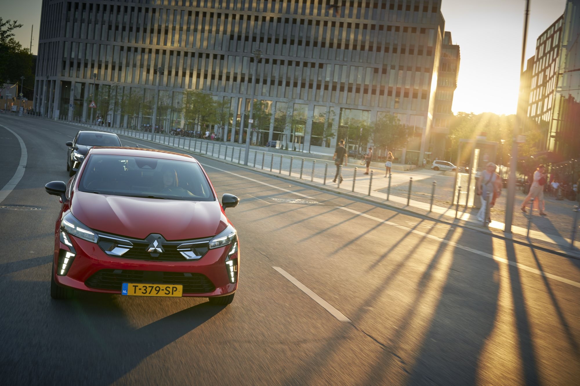 Captura dinámica del Mitsubishi Colt híbrido tomando una curva en la ciudad.