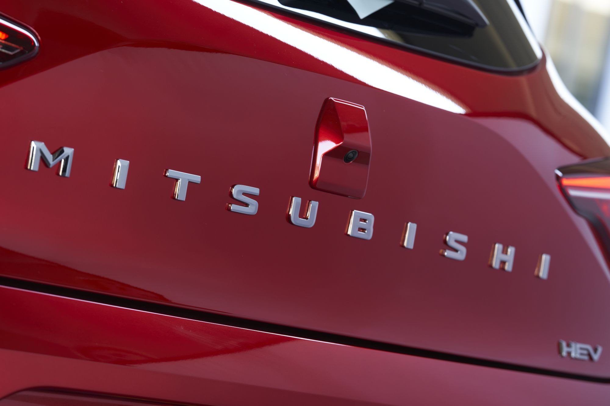 Vista trasera que destaca el elegante diseño y logotipo del Mitsubishi Colt híbrido.