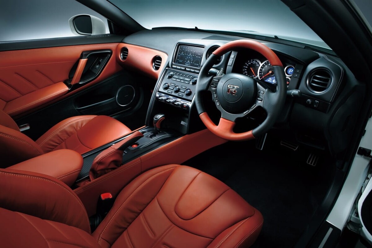 Interior elegante con enfoque en los asientos de cuero rojo del Nissan GT-R. Interior elegante con enfoque en los asientos de cuero rojo del Nissan GT-R.