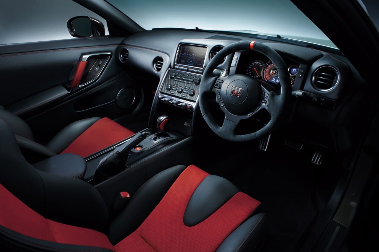 Vista del habitáculo del Nissan GT-R, con detalles en rojo y negro.