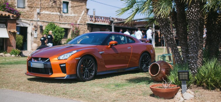 Nissan GT-R mostrando su perfil lateral en un ambiente rústico.