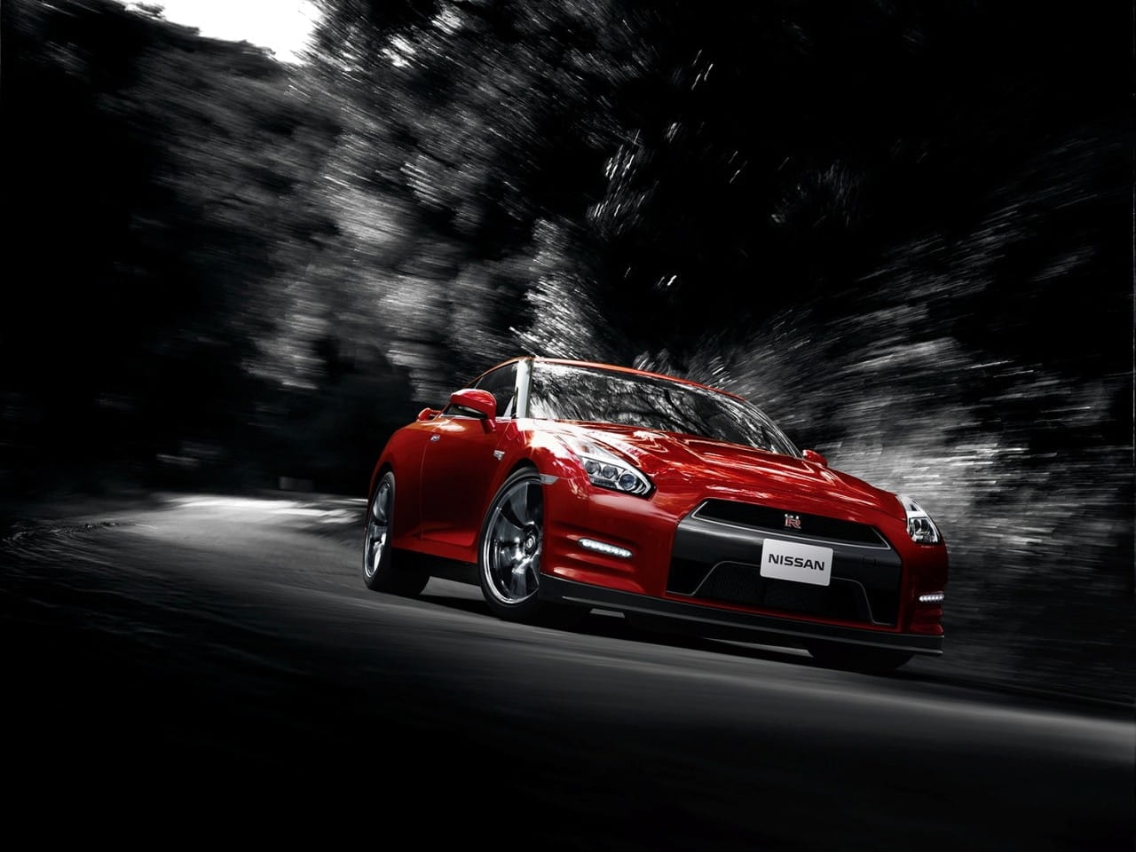 El Nissan GT-R rojo capturado en plena aceleración, mostrando su dinamismo.