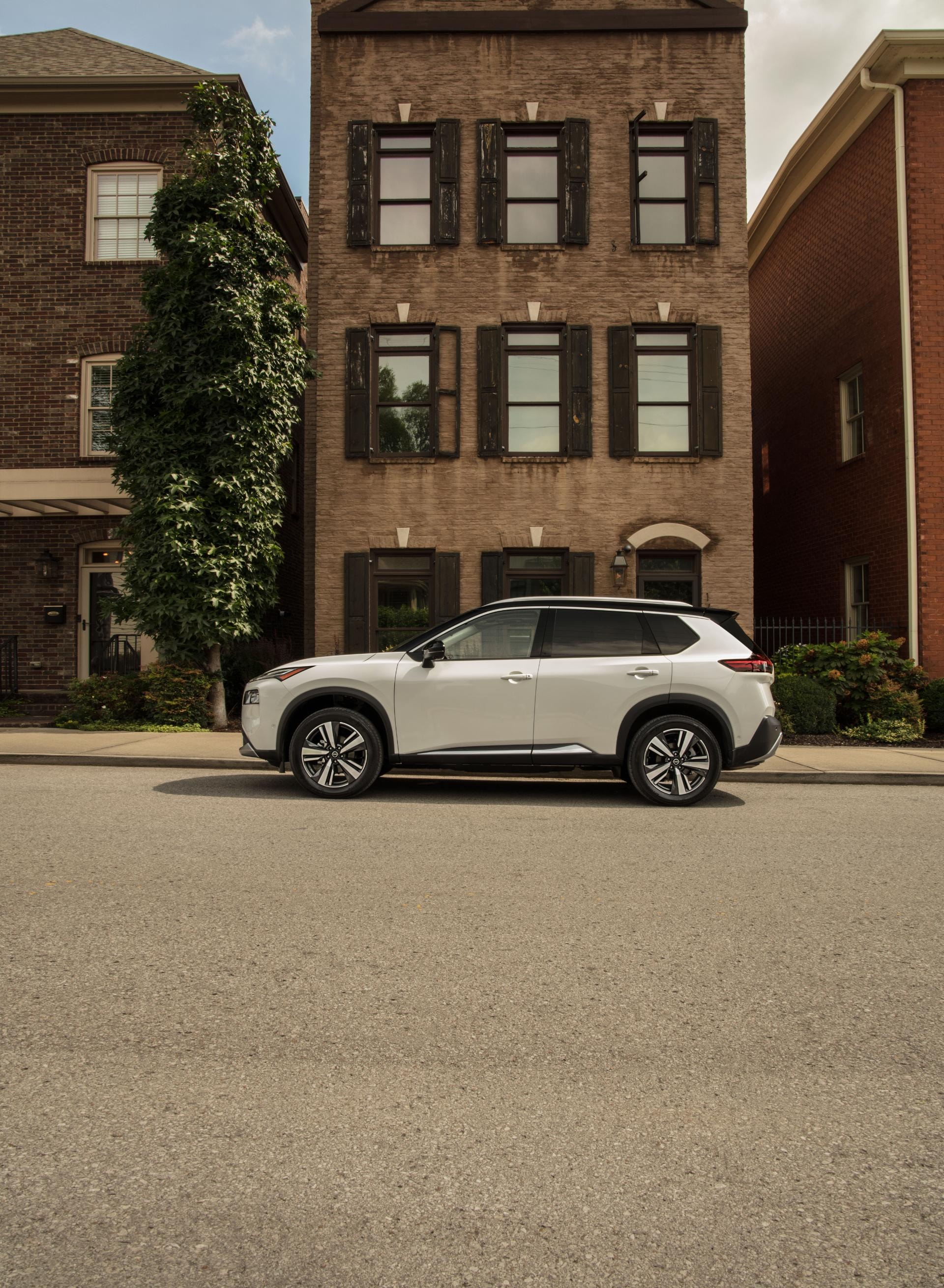 El Nissan X-Trail híbrido se sitúa en un entorno urbano, mostrando su perfil lateral.