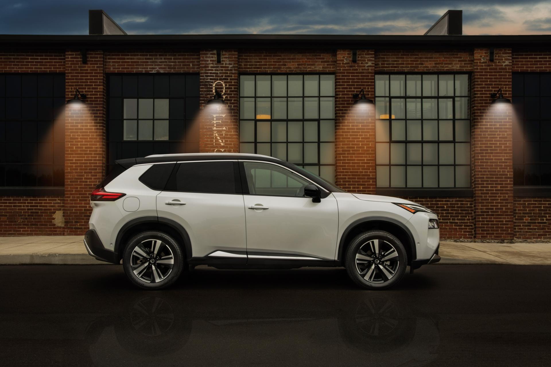 Perfil lateral del Nissan X-Trail híbrido mostrando su diseño en un entorno urbano.